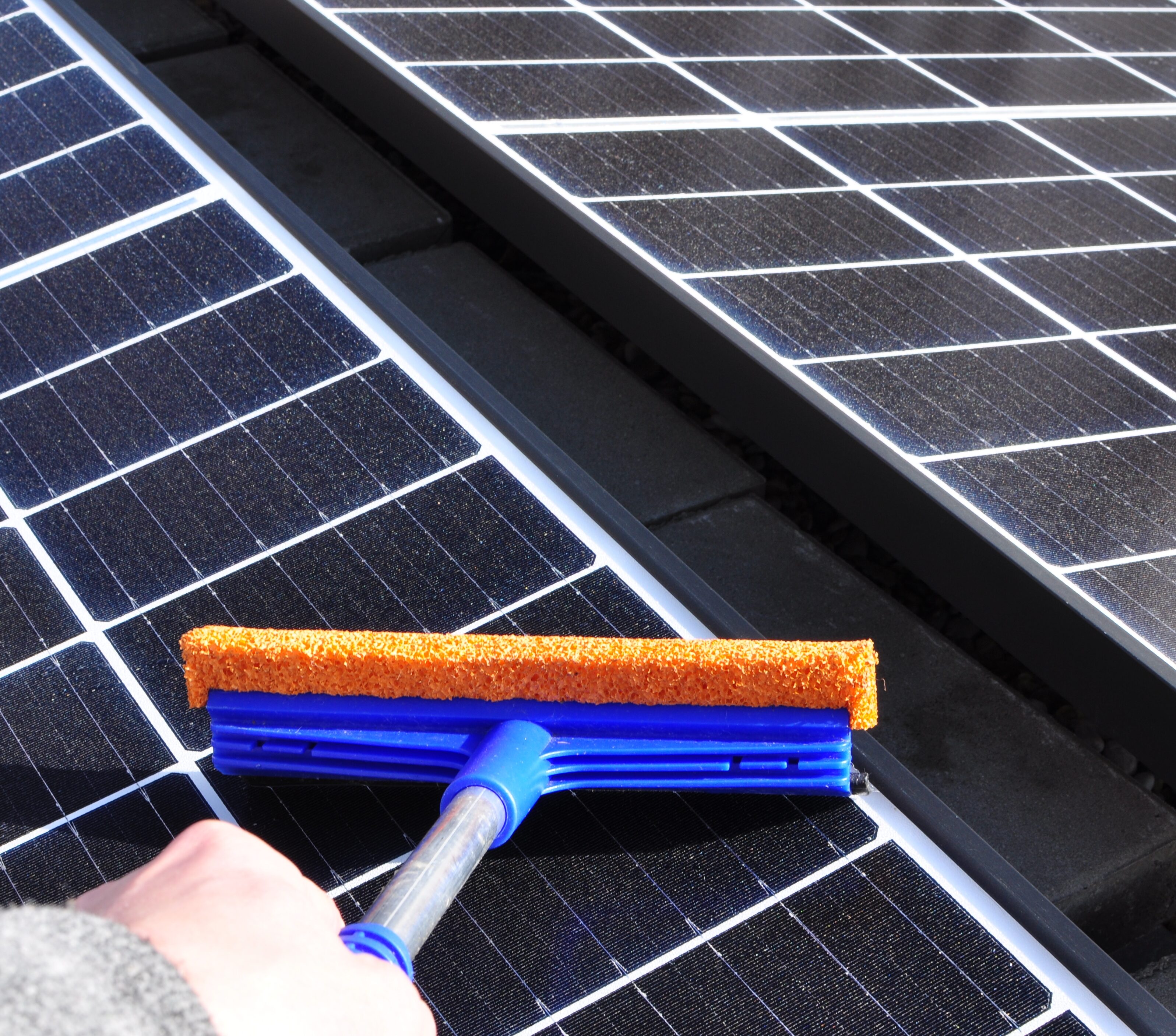 Cleaning solar panels with a wiper